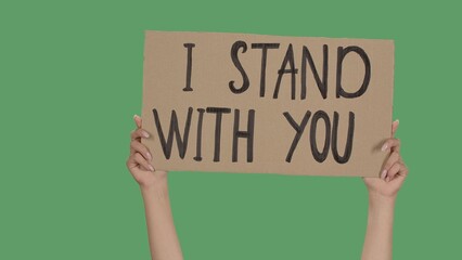 Hands of women raising up cardboard poster I STAND WITH YOU. Stop Racism concept, No Racism....