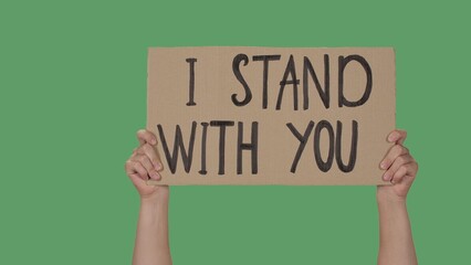 Hands of men raising up cardboard poster I STAND WITH YOU. Stop Racism concept, No Racism. Rallies...