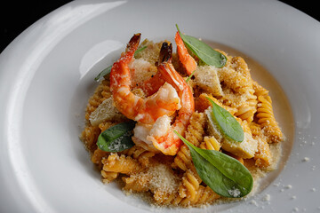 Pasta with shrimps, cheese and spices on a plate