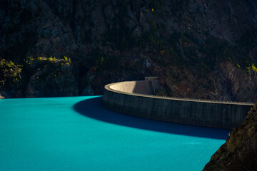 Dam of the Lake Place Moulin, an artificial glacial lake with turquoise water in the italian Alps, ...
