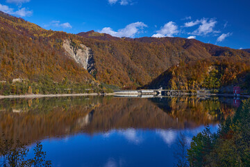 Fototapeta na wymiar Dam lake and colorful forests in the autumn
