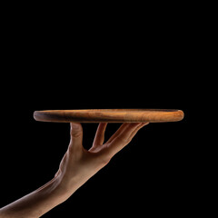 Man's hand with a round wooden board for making pizza or other food.