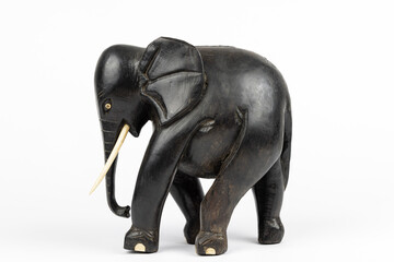 wooden statue of a black african elephant with ivory tusks and toes, isolated on white blackground 
