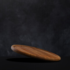 Round wooden pizza board falling on a black background. Food preparation. Culinary background.