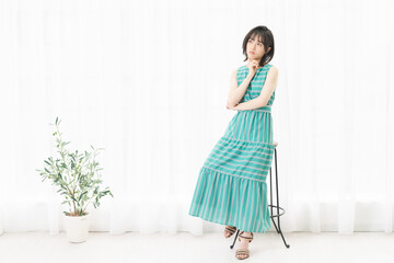 窓際で考えているポーズをする若い女性