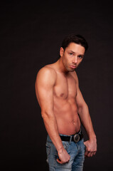 Fototapeta premium Young attractive guy posing in the studio. Beautiful body.