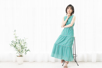 窓際で考えているポーズをする若い女性