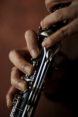 the hands of a musician on the clarinet - an ancient musical wooden instrument popular in classical...