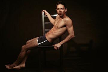 Young attractive guy posing in the studio. Beautiful body.