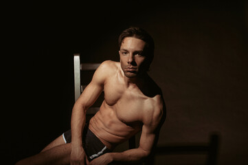 Young attractive guy posing in the studio. Beautiful body.