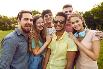 Bunch of happy young diverse people meet up, enjoy summer and have fun together. Group portrait of...