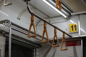 The hand handle or handgrips or handrails of commuter line passengers swaying due to the movement of the train. © CindhyAde