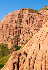 Fototapeta premium Amazing landmark in Transylvania. Wide view of Red Ravine (Rapa Rosie in Romanian language) clay soil mountain shapes during a beautiful sunny day.