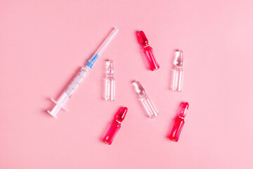 Beautiful closeup of tablet vitamin for women on pink background . Medical healthcare ampoules with syringes. Medicine medical health. 