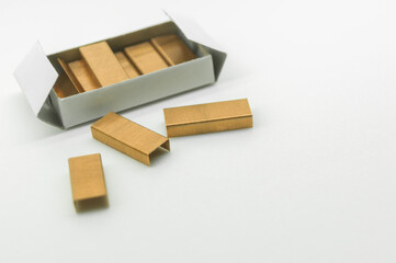 Stationery staples for stapler in a box on a white background. A set of new staples for fastening sheets of paper with a stapler. Selective focus