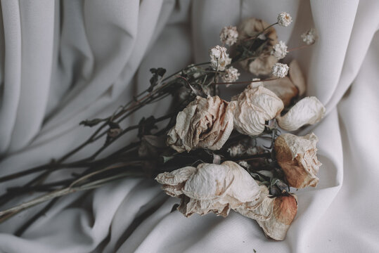 Soft fabric and dried flowers, Flowers on a bed, Rustic ribbon, Photo of dried flowers, Flower tied with vintage rope © natia