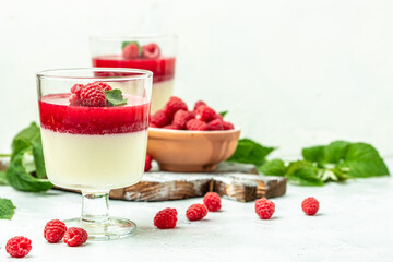 Italian dessert. Raspberry Panna cotta with raspberry jelly on a light background. Berry dessert with cream sauce in small jars. Long banner format. place for text