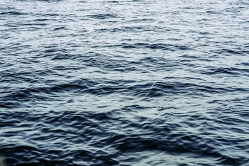 Bright blue Ocean water ripples background on a sunny day. Clean water consumption and natural resources