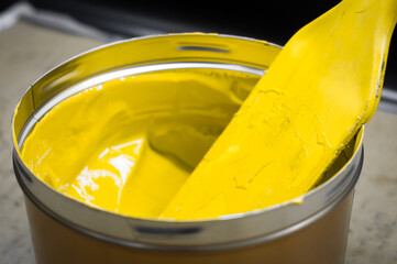 A can of yellow polygraph offset paint for the printing press. Special UV ink for printing. Open...