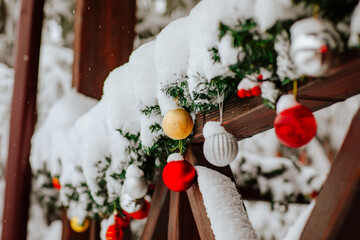 Christmas decor with toys and lights on outdoor home terrace. Snowing background
