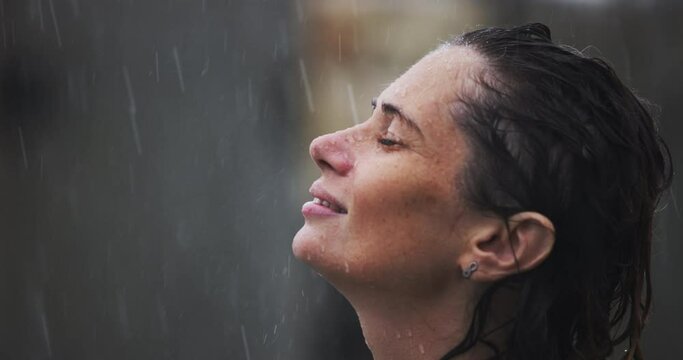 Close-up portrait of adult girl with wet hair. a happy healthy Caucasian woman smiles in the rain, a woman immersed in nature, enjoying the rainy weather. concept of positive thinking, love, freedom.