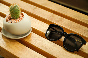 sunglasses are on the slatted table.Horizontal composition. Front view.