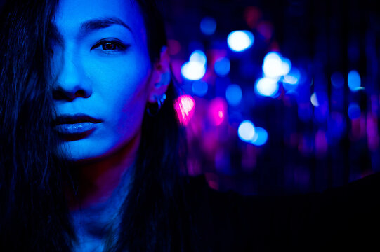 Portrait of a transgender model in a studio with neon lighting.