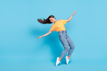 Fototapeta na wymiar Full length photo of adorable pretty lady wear yellow t-shirt dancing having fun empty space isolated blue color background