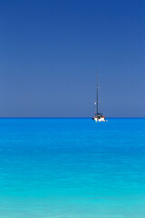 Fototapeta na wymiar White yacht anchored in fantastic Myrtos Beach turquoise and blue bay. Summer scenery of famous and extremely popular travel destination in Cephalonia island, Greece, Europe.