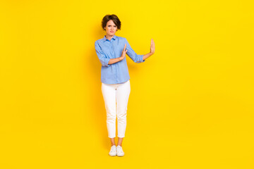 Full length photo of unsure moody lady wear blue shirt rising arms empty space isolated yellow...