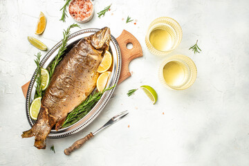baked fish with lemon herbs and spices. two glasses of white wine, dinner concept. Restaurant menu, dieting, cookbook recipe top view