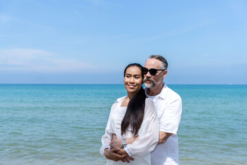 A couple of men and women of different nationalities go to the beach and walk happily on the beach together. on summer vacation