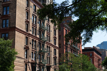 Row of Old Brick Apartment Buildings with Fire Escapes along a Street on the Upper West Side of New York City