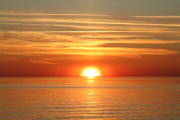 Sunsetting sky above calm sea during the dusk. Selective focus