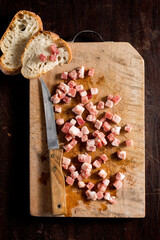 Raw Pancetta - Bacon cubes on wooden surface