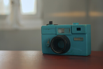 a blue toy camera on a wooden table