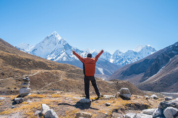 Rear view of tourist raised his hands while looking to beautiful view of Mt.Ama Dablam and...