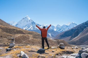 Crédence de cuisine en verre imprimé Ama Dablam Rear view of tourist raised his hands while looking to beautiful view of Mt.Ama Dablam and Himalayas range from Thukla Pass (4800 m) a memorial viewpoint lying along the Everest Base Camp route.