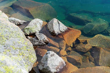 River stones stick out from under the clear water