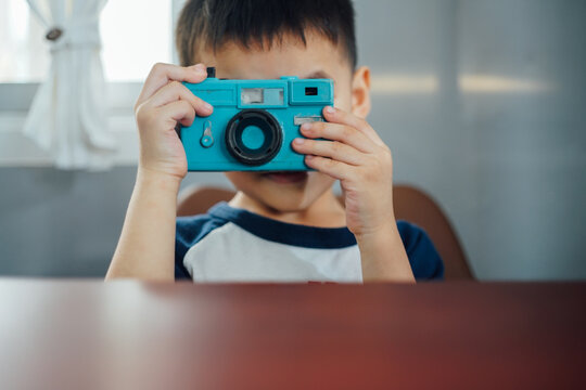 Asian children are taking pictures with a DSLR. 