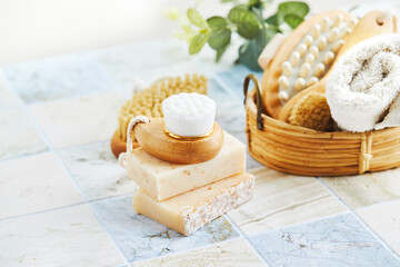 Two bars of soap, wash and massage brushes, and rolled towel. Hy