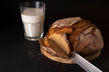 round bread on the board next to the glass of milk