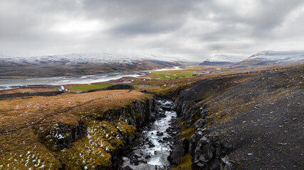 Hengifoss waterfall canyon with orange grass and floating water