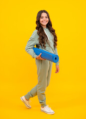 Naklejka premium Girl teenager in tracksuit. Happy cute child in a yellow sports suit on a yellow background. Sportswear advertising concept.