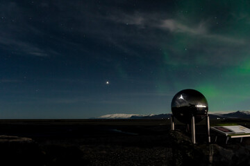 Fototapeta na wymiar metal monument of sun in Höfn í Hornafirði with stars and northern lights on background 