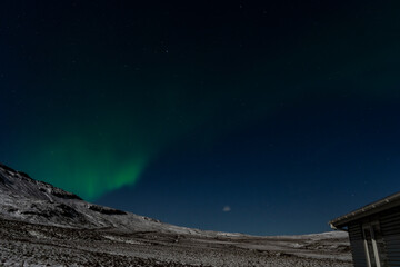 Fototapeta na wymiar aurora borealis northern liths over snowy mountain