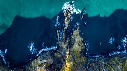 aerial view on icelandic rocky coast with green grass and blue water of ocean - Powered by Adobe