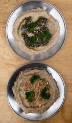 Vegan cuisine. Top view of traditional middle eastern chickpeas hummus and eggplant baba ganoush on the wooden table.