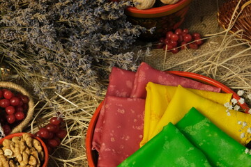 Multicolored pancakes. Pancake green, pink, yellow. Rural background, milk, hay, straw, walnut,...