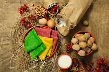 Multicolored pancakes. Pancake green, pink, yellow. Rural background, milk, hay, straw, walnut,...